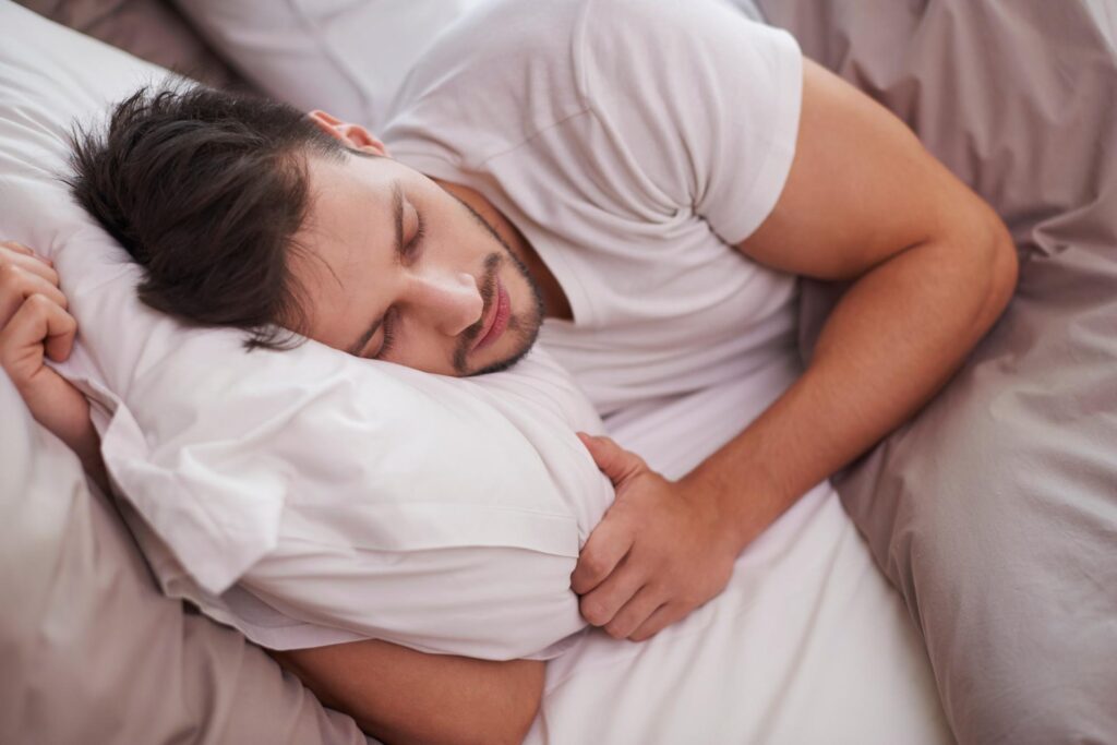 Man sleeping peacefully on his side, highlighting the importance of rest in a healthy skincare routine