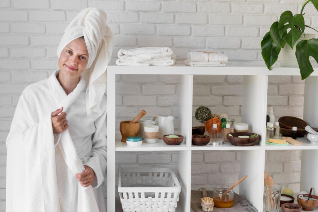 Natural beauty routine featuring a woman with DIY skincare ingredients, wooden mortar and pestle, and organic products on a white shelf.
